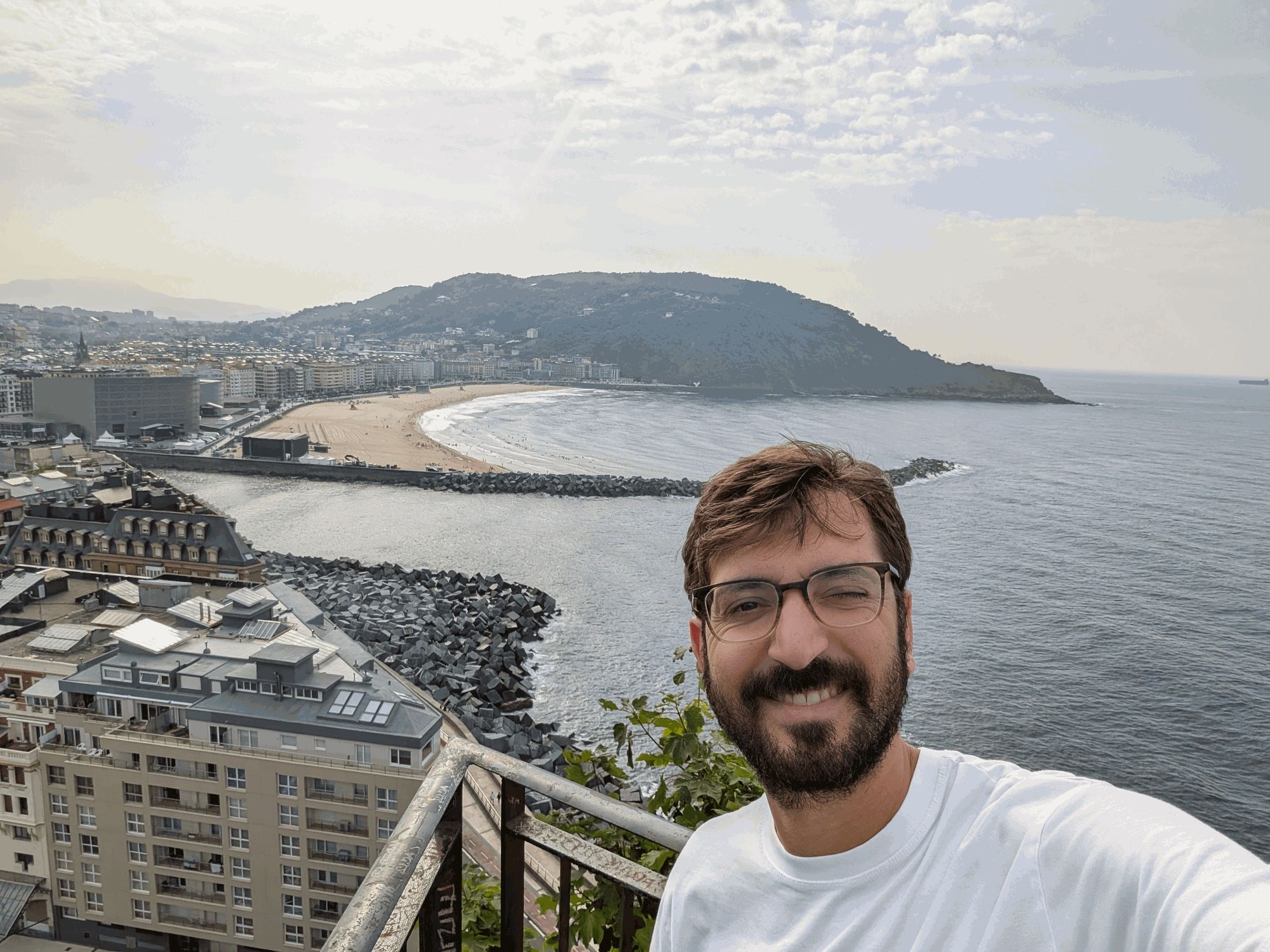 Namir smiling on a viewpoint above a beach and the sea